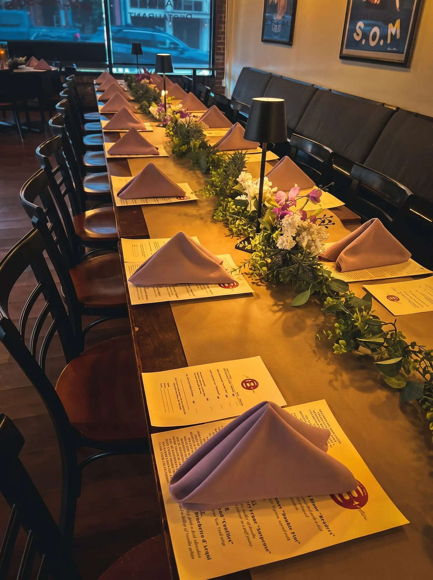 The private dining room set for a party, one long table under warm lanterns.